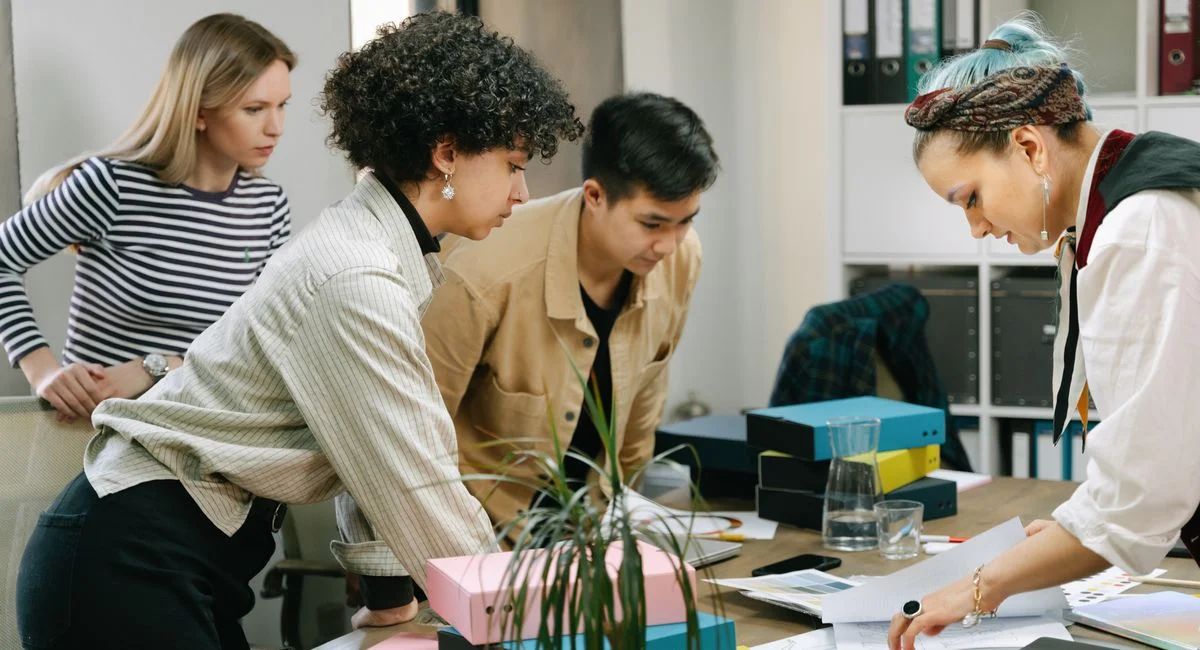 A diverse team of colleagues collaborating on a business project in a modern office setting.