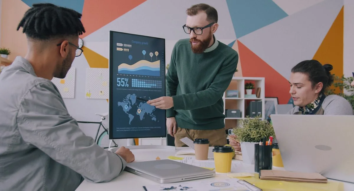 Team collaboration on business growth strategy with data charts in a modern office.