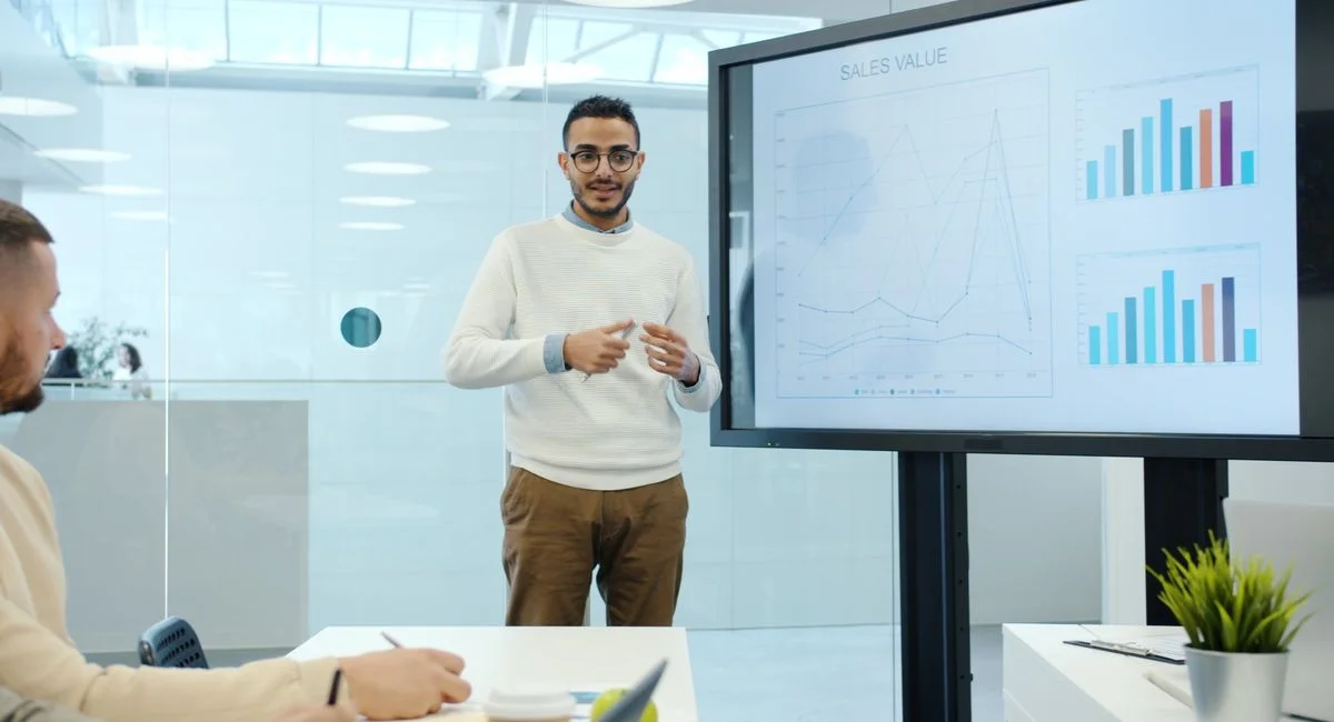 Professional delivering business presentation with charts in modern office setting.