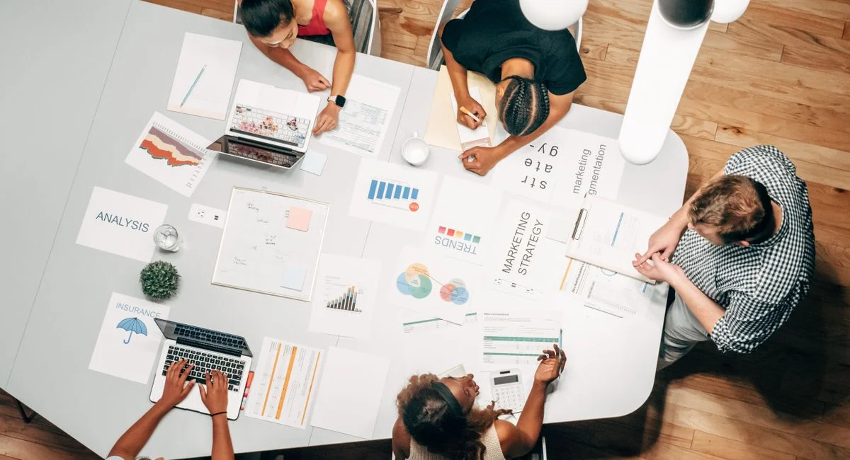 Diverse team collaborating on marketing strategy in a modern office setting.