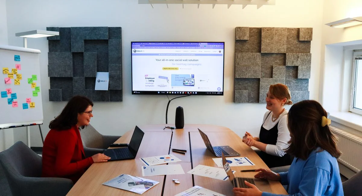 A team of women collaborating in a business meeting with laptops and presentations.
